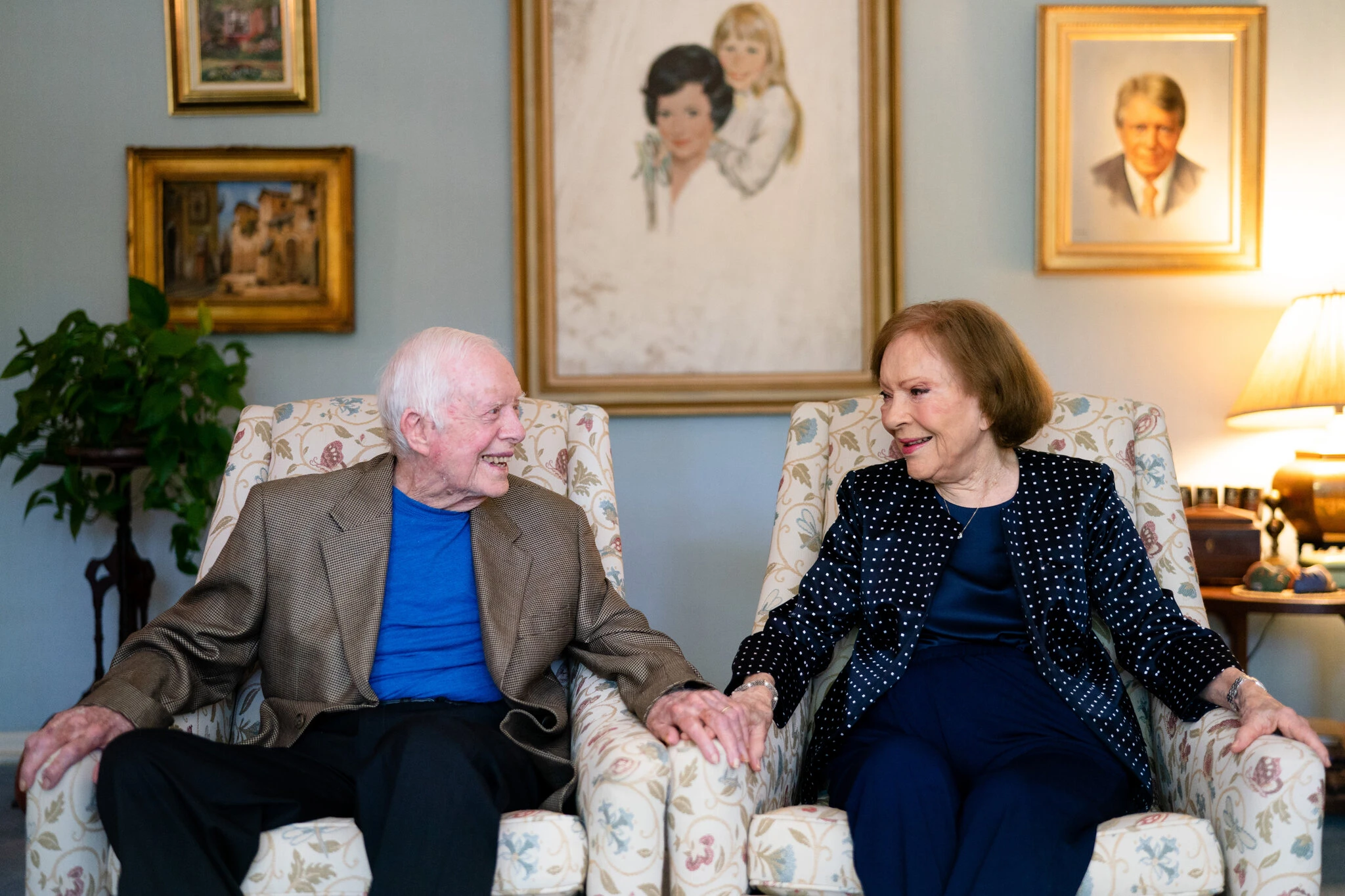 A more recent photo of Jimmy and Rosalynn Carter, smiling and holding hands.